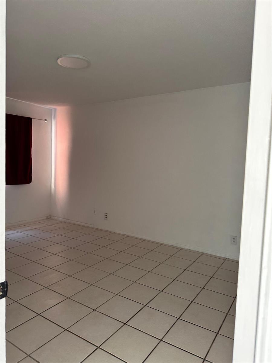 An empty room with white walls, tiled flooring, and a window with red curtains — 13707 Kendale Lakes Circle, Miami FL 33183, MIAMI, FL