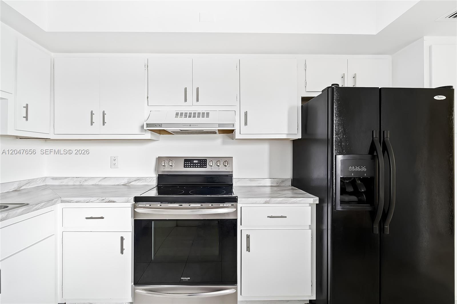 A kitchen features white cabinets, a stainless steel stove, and a black refrigerator — 4500 Gefion Ct # 304, Lake Worth FL 33467, LAKE WORTH, FL
