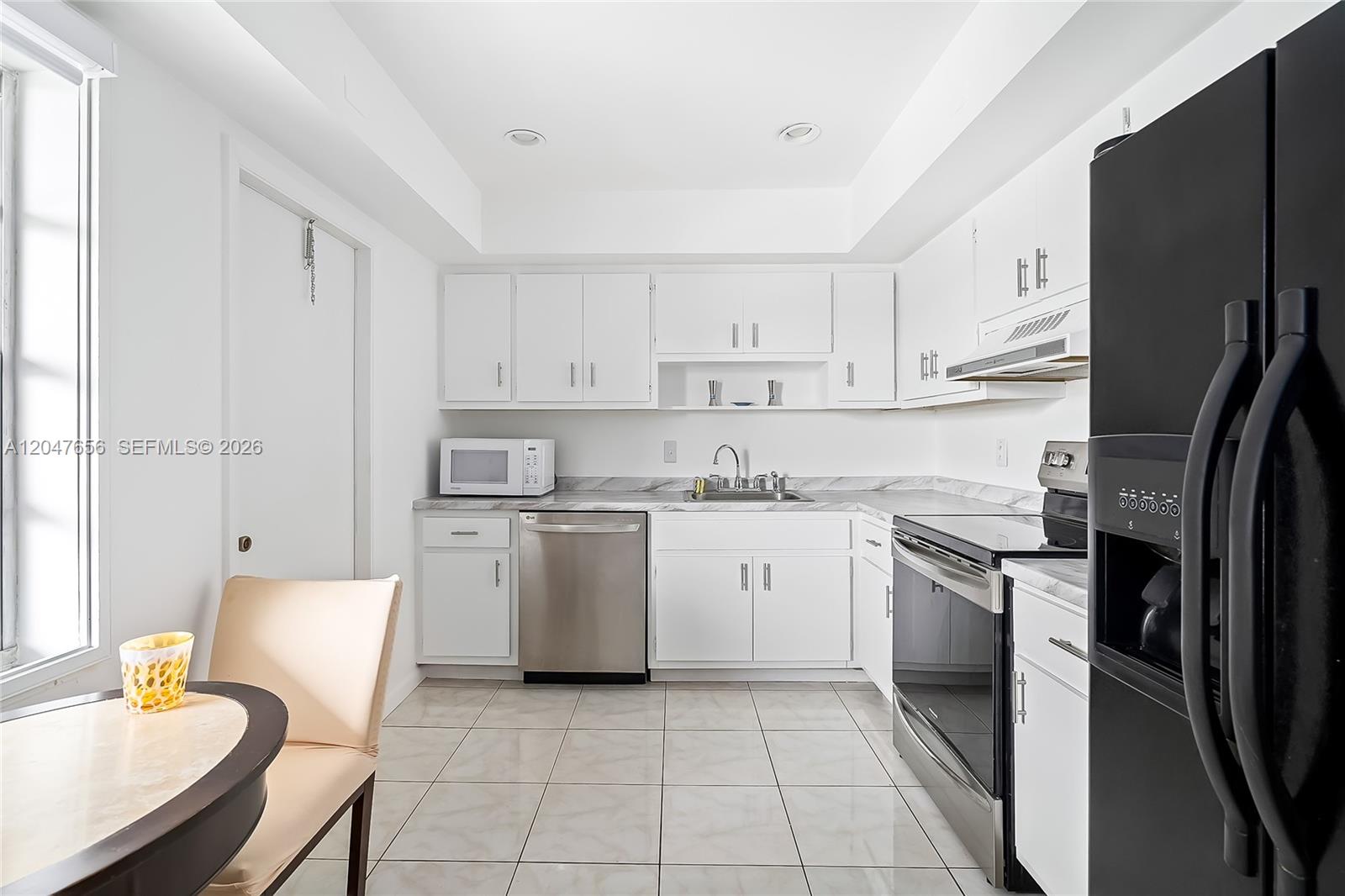 A kitchen with white cabinets, stainless steel appliances, and light-colored tile flooring — 4500 Gefion Ct # 304, Lake Worth FL 33467, LAKE WORTH, FL