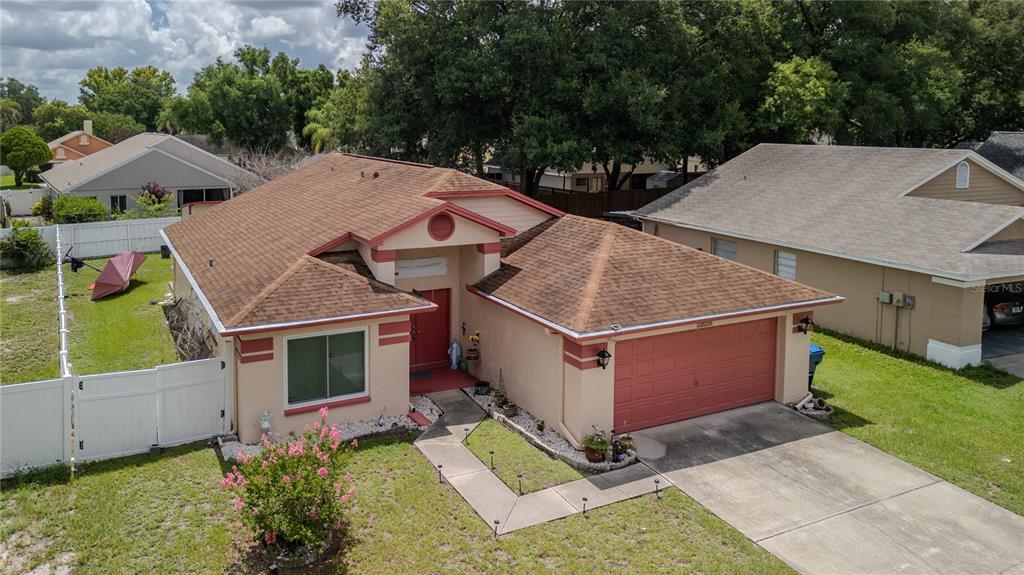 An aerial view of a single-story house with a tan exterior, red trim, and garage — 1604 COPPERSMITH COURT, LUTZ, FL