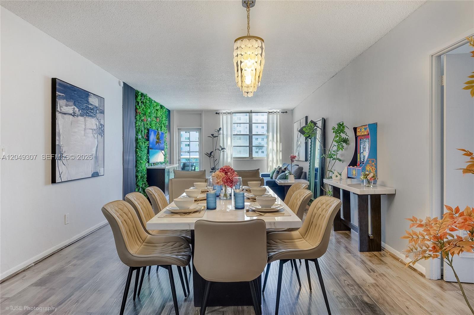 A dining room features a white table, tan upholstered chairs, and a green accent wall — SUNNY ISLES BEACH, FL