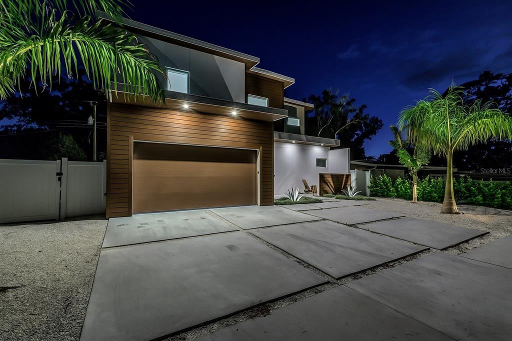 A modern two-story house with a brown garage, concrete driveway, and palm trees at night — 2314 FLOYD STREET, SARASOTA, FL