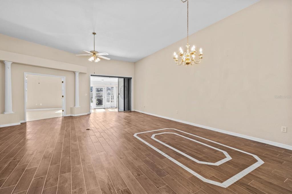 A spacious room features wood-look tile flooring with a decorative white inlay border — 2788 COUNTRY WAY, CLEARWATER, FL