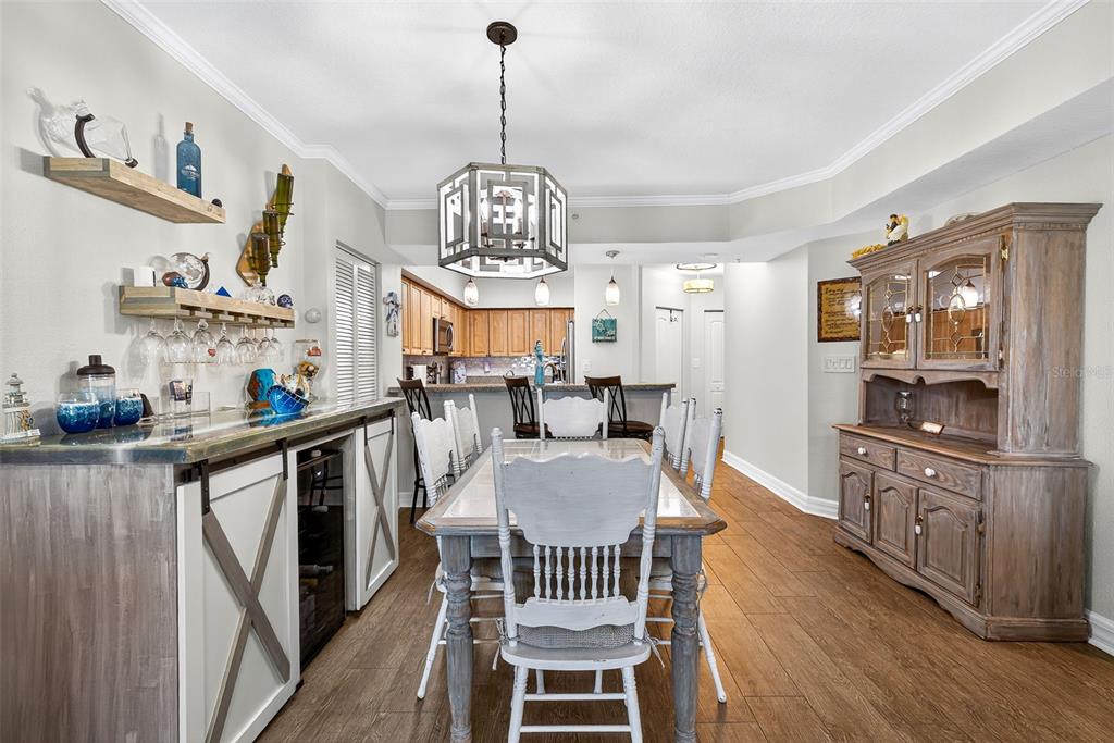 A dining room features a wooden table, white chairs, a bar area, and a hutch — 4516 SEAGULL DRIVE UNIT 519, NEW PORT RICHEY, FL