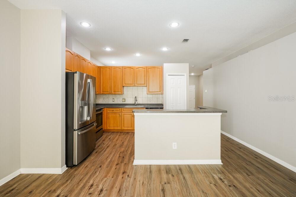 A kitchen with wood cabinets, stainless steel appliances, and wood-look flooring — 12923 TERRACE SPRINGS DRIVE, TEMPLE TERRACE, FL