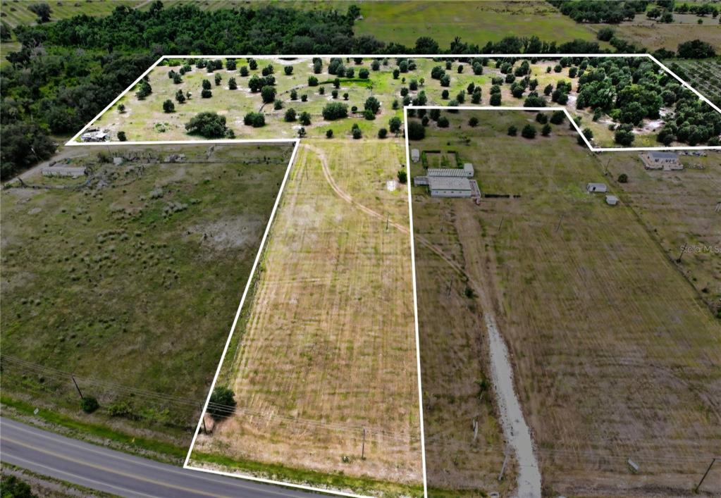 An aerial view shows a large, irregularly shaped plot of land with trees and grass — NW 70 HIGHWAY NW, ARCADIA, FL