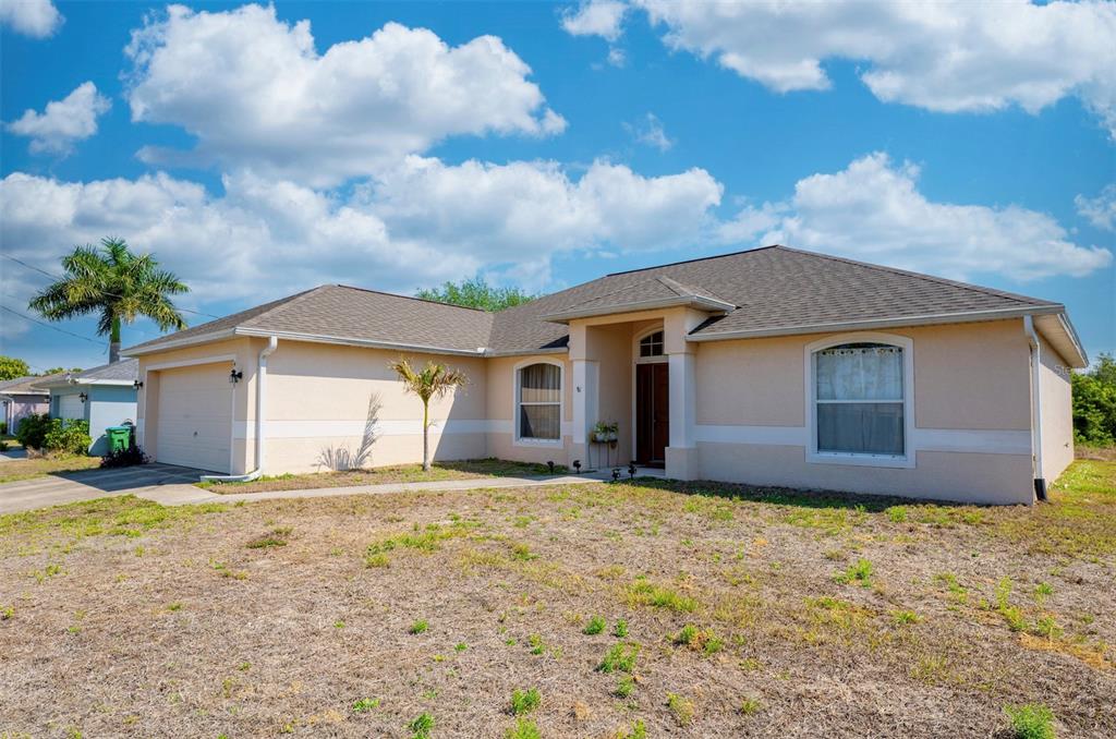 A single-story house with a tan stucco exterior, arched windows, and a covered front entrance — 4129 NE 19TH PLACE, CAPE CORAL, FL