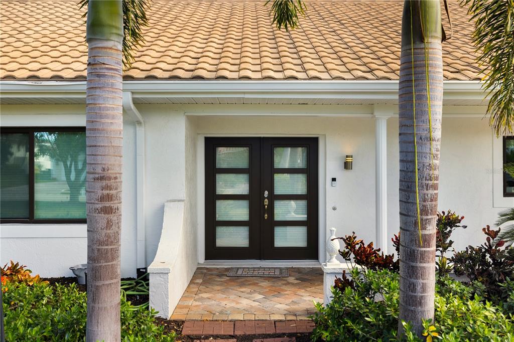 A front entrance features a dark brown double door with glass panels and a tiled walkway — 3727 TANGIER TERRACE, SARASOTA, FL