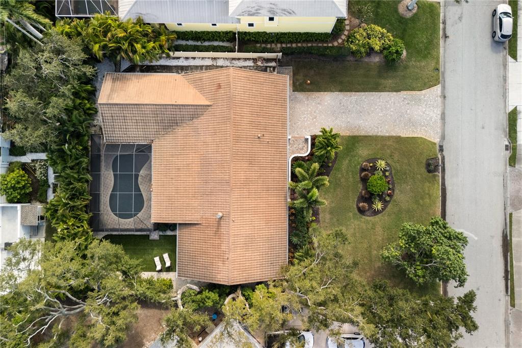 An aerial view shows a house with a tiled roof, a screened pool, and landscaping — 3727 TANGIER TERRACE, SARASOTA, FL