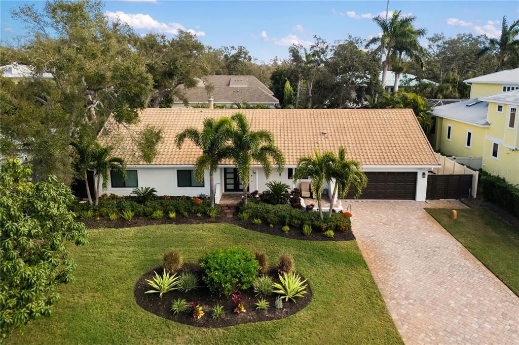 An aerial view of a single-story house with a tiled roof, palm trees, and driveway — 3727 TANGIER TERRACE, SARASOTA, FL