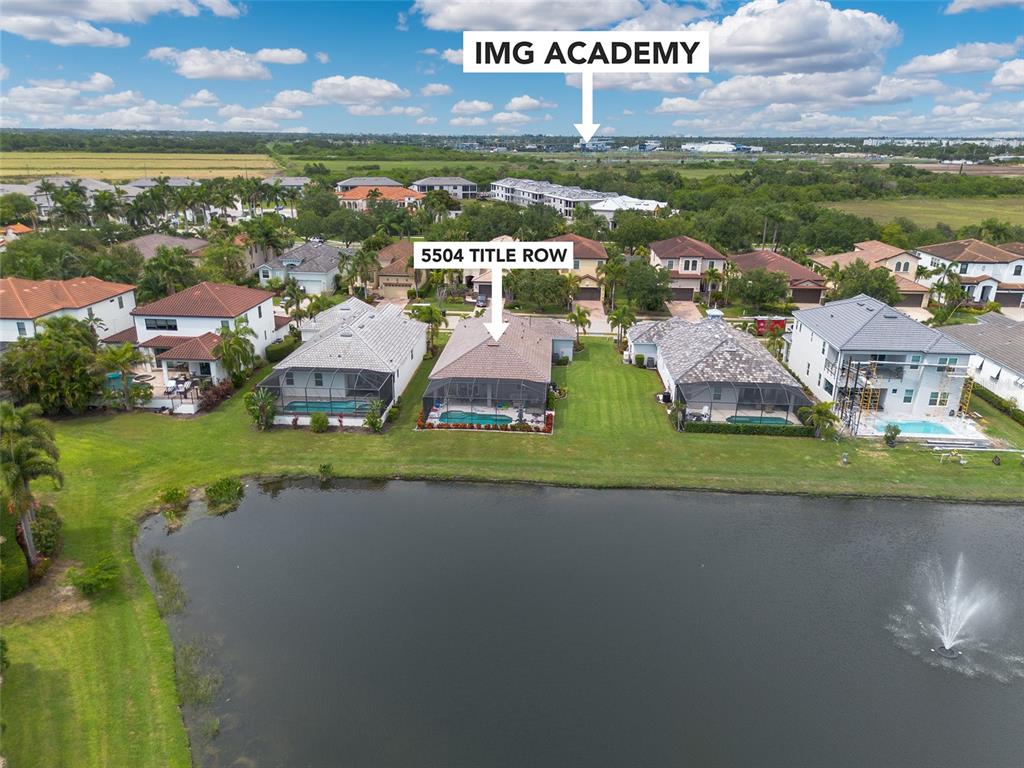 An aerial view shows a residential house with a pool overlooking a lake — 5504 TITLE ROW DRIVE, BRADENTON, FL