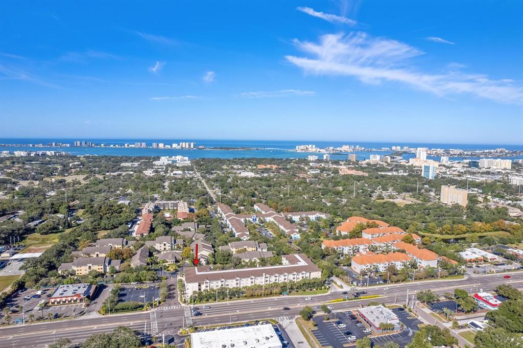An aerial view shows a multi-story apartment complex with a red arrow pointing to a unit — 1216 S MISSOURI AVENUE UNIT 226, CLEARWATER, FL