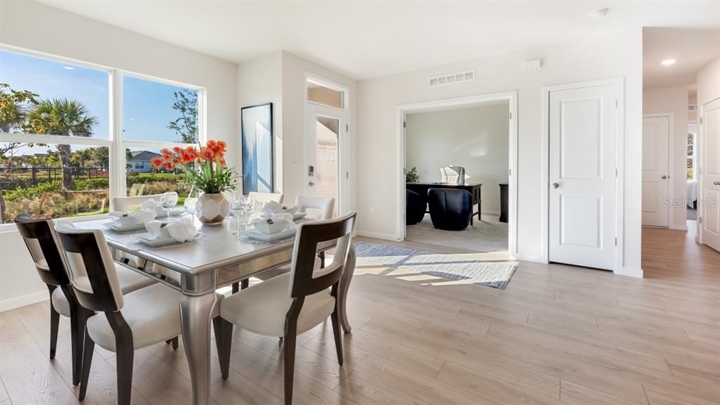A dining area with a table and chairs sits next to a home office space — 16282 BRIDLE RIDGE STREET, PORT CHARLOTTE, FL