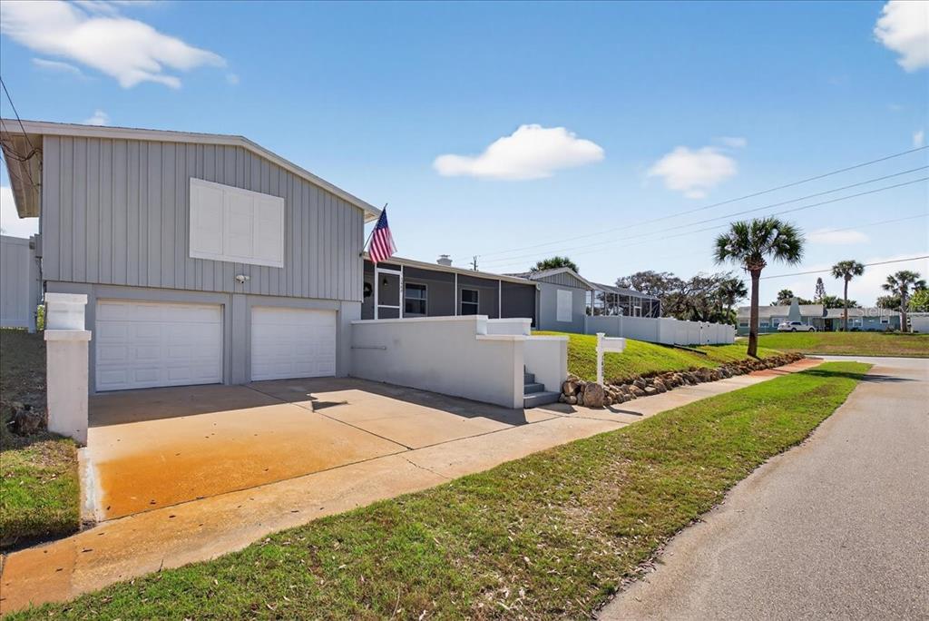 A gray house with a two-car garage, a front porch, and a concrete driveway — 1600 N OLEANDER AVENUE, DAYTONA BEACH, FL