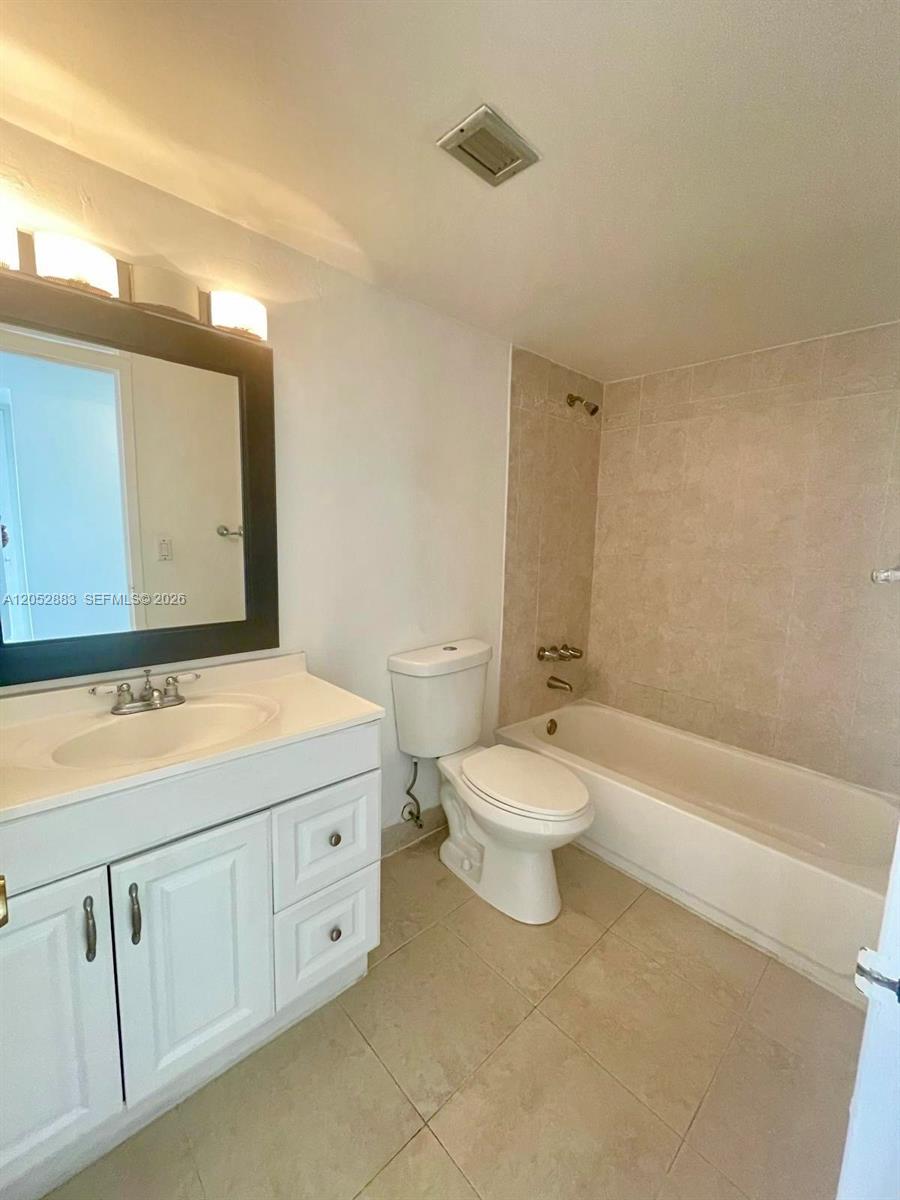 This bathroom features a white vanity, a toilet, and a shower-tub combination with beige tile — 13155 Ixora Ct # 201, North Miami FL 33181, NORTH MIAMI, FL