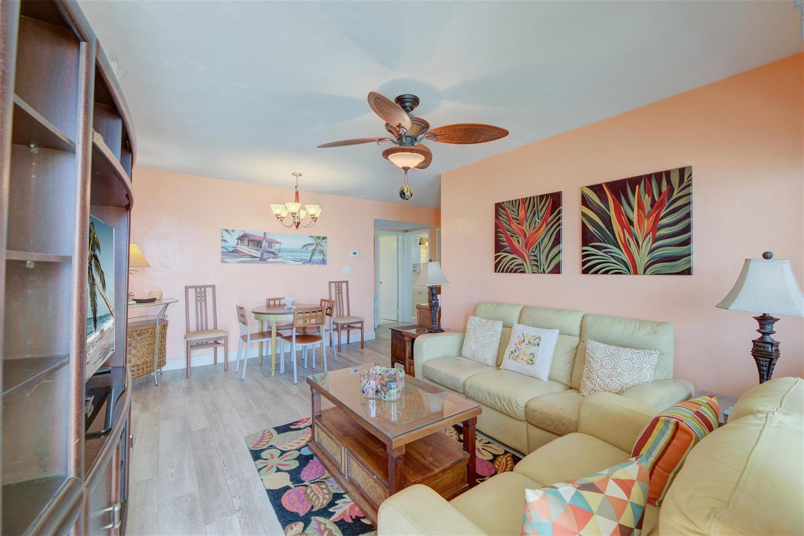 A living and dining area with peach walls, light wood flooring, and a ceiling fan — 1815 N Surf Road # 403, Hollywood FL 33019, HOLLYWOOD, FL