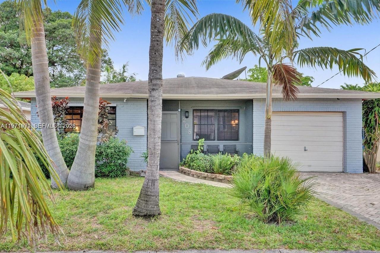A single-story house with a light blue brick exterior, a garage, and palm trees — 208 SW 2nd Ave, Hallandale Beach FL 33009, HALLANDALE BEACH, FL