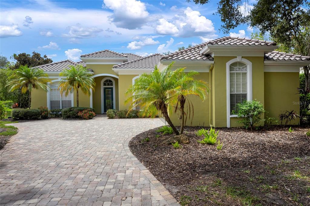 A single-story house with a paved driveway, palm trees, and a tiled roof — 29 SAINT JOHN BOULEVARD UNIT 5, ENGLEWOOD, FL