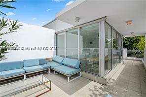 A patio features light blue outdoor seating and a glass-enclosed room under a white overhang — 1600 Michigan Ave # 7, Miami Beach FL 33139, MIAMI BEACH, FL