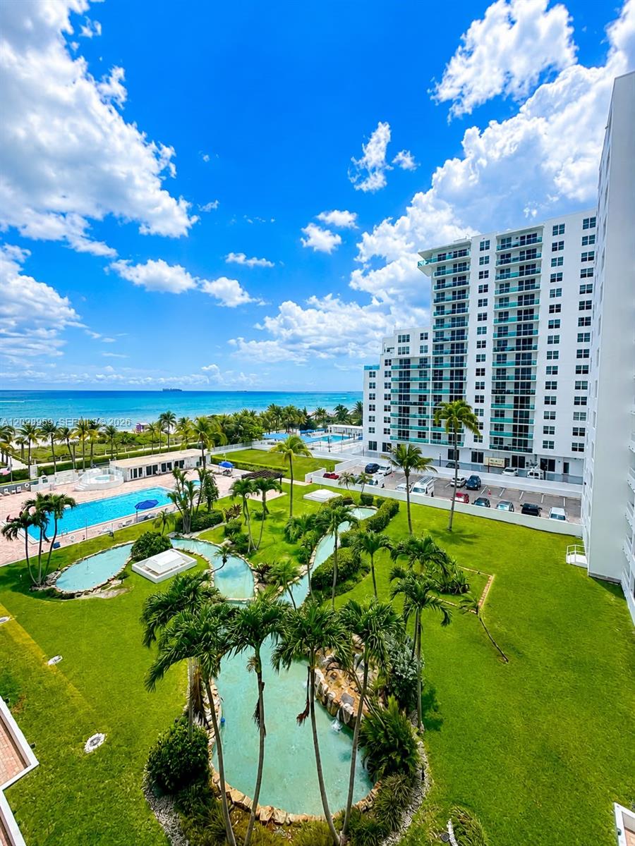An elevated view shows a tropical resort with a swimming pool, landscaped ponds, and oceanfront buildings — 5005 Collins Ave # 616, Miami Beach FL 33140, MIAMI BEACH, FL