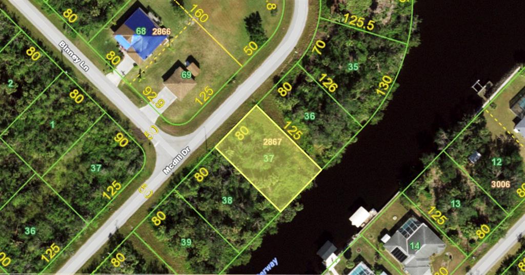 This is an aerial map showing a vacant residential lot highlighted in yellow — 594 MCDILL DRIVE, PORT CHARLOTTE, FL