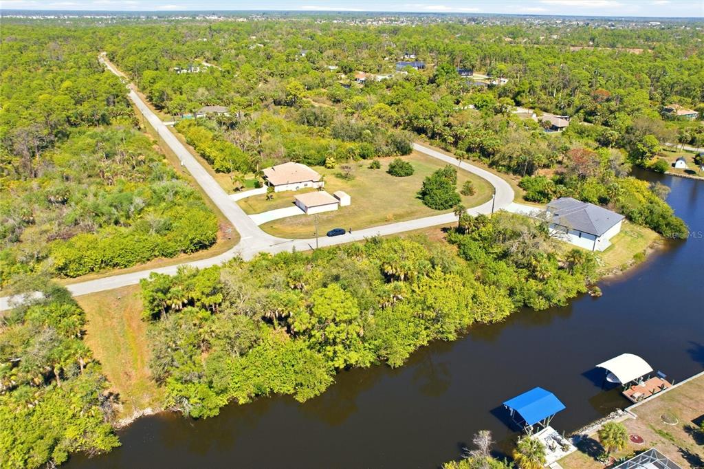 An aerial view shows a residential property with a house, driveway, and canal access — 594 MCDILL DRIVE, PORT CHARLOTTE, FL