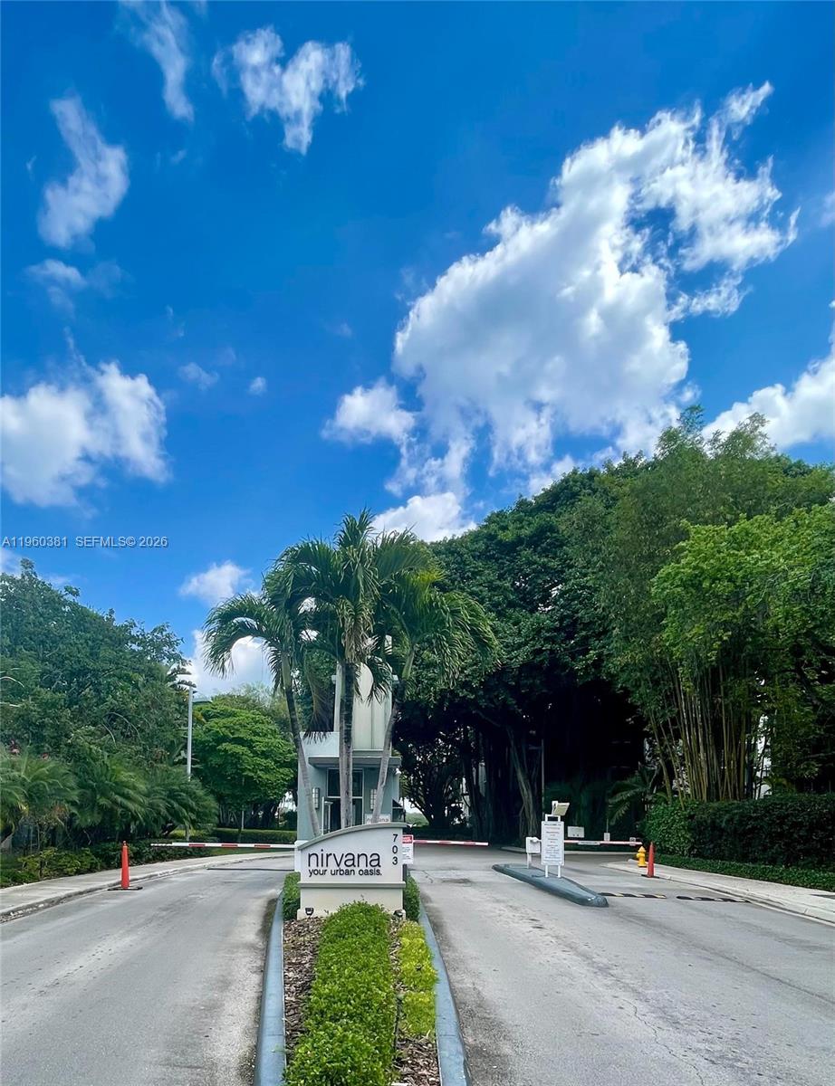 A gated entrance with a sign reading Nirvana leads into a lush, tree-lined residential property — 700 NE 63rd St # D203, Miami FL 33138, MIAMI, FL