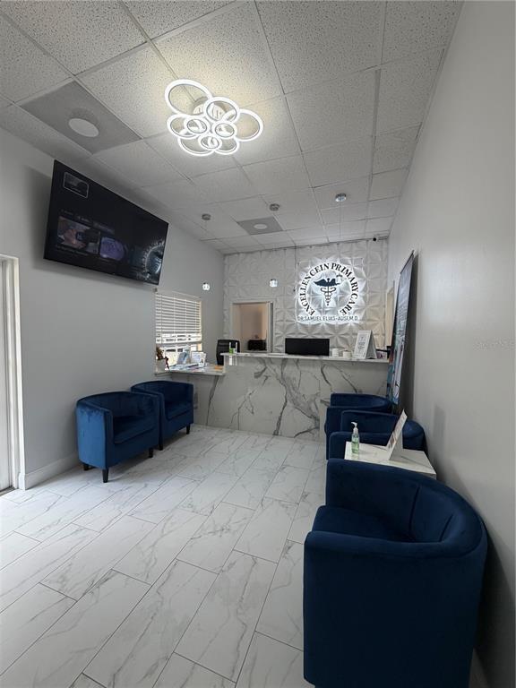 A medical office waiting room features blue velvet chairs, marble-look flooring, and a reception desk — 2716 REW CIRCLE, OCOEE, FL