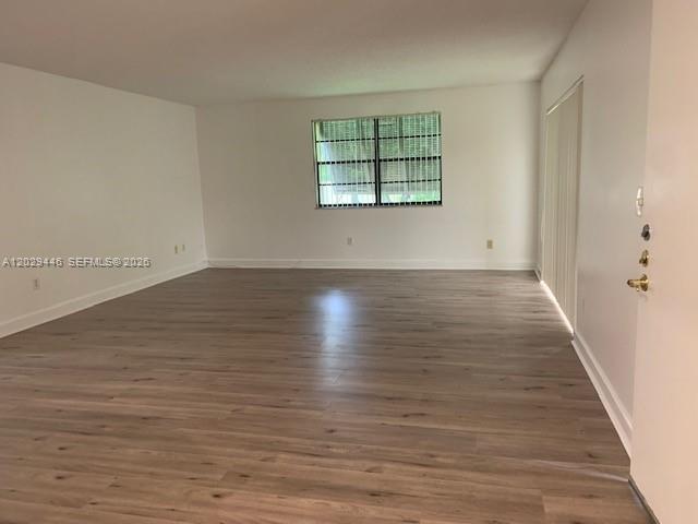 An empty room features light wood-look flooring, white walls, and a single window — 7915 SW 86th St # 726, Miami FL 33143, MIAMI, FL