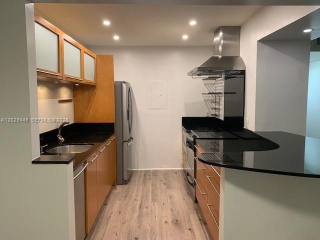 A kitchen features light wood cabinets, black countertops, stainless steel appliances, and wood-look flooring — 7915 SW 86th St # 726, Miami FL 33143, MIAMI, FL