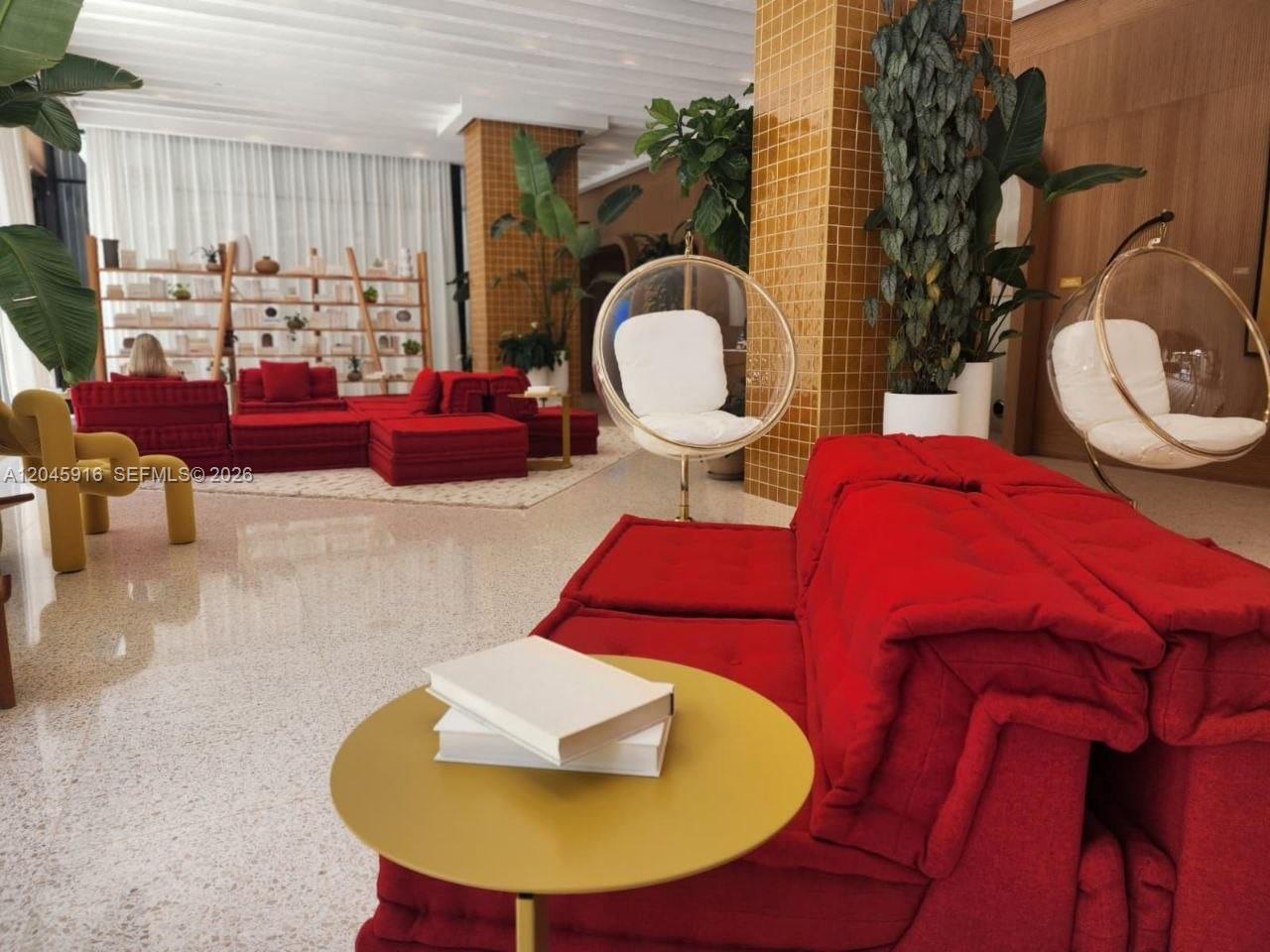 A modern lounge area features red modular sofas, bubble chairs, and yellow tiled columns — 90 NE 32nd # 511, Miami FL 33127, MIAMI, FL