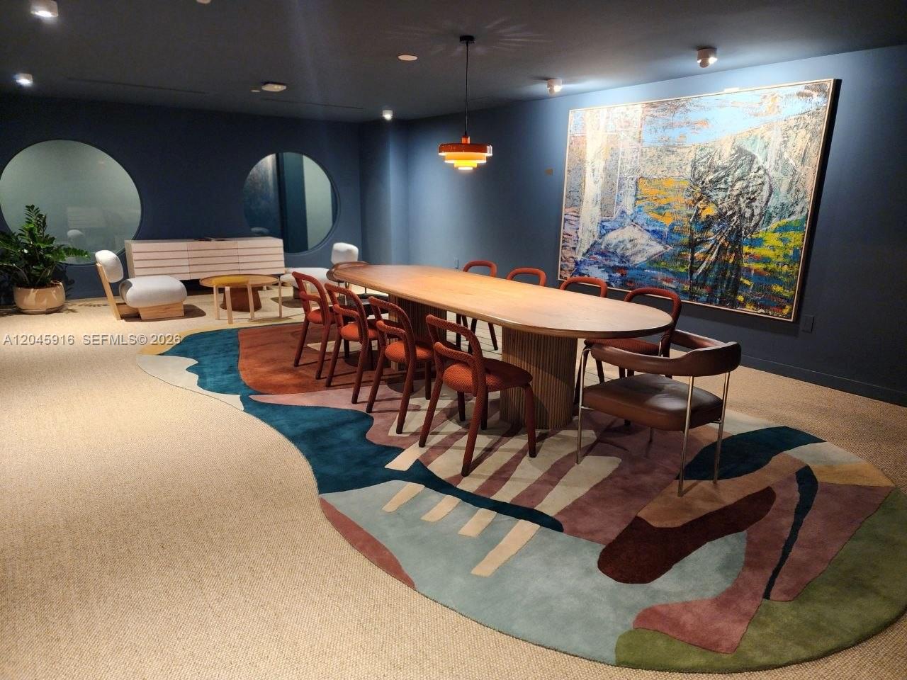 A dining room features a long wooden table, modern chairs, and a large abstract rug — 90 NE 32nd # 511, Miami FL 33127, MIAMI, FL