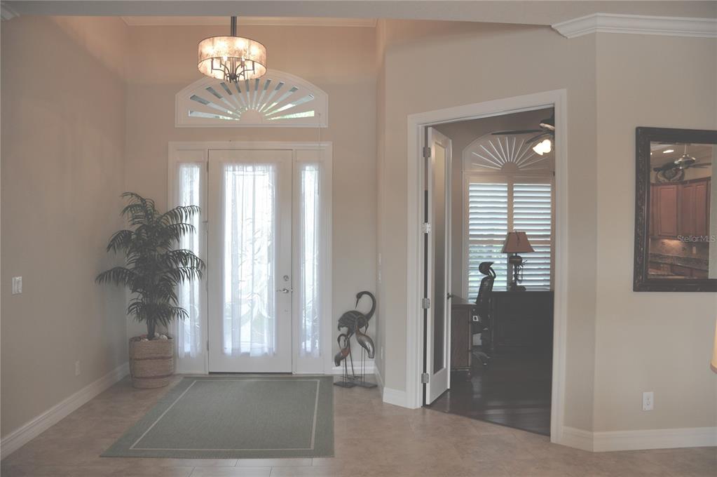 A bright entryway features tile flooring, a glass-paneled front door, and an adjacent home office — 3293 TRIPOLI BOULEVARD, PUNTA GORDA, FL
