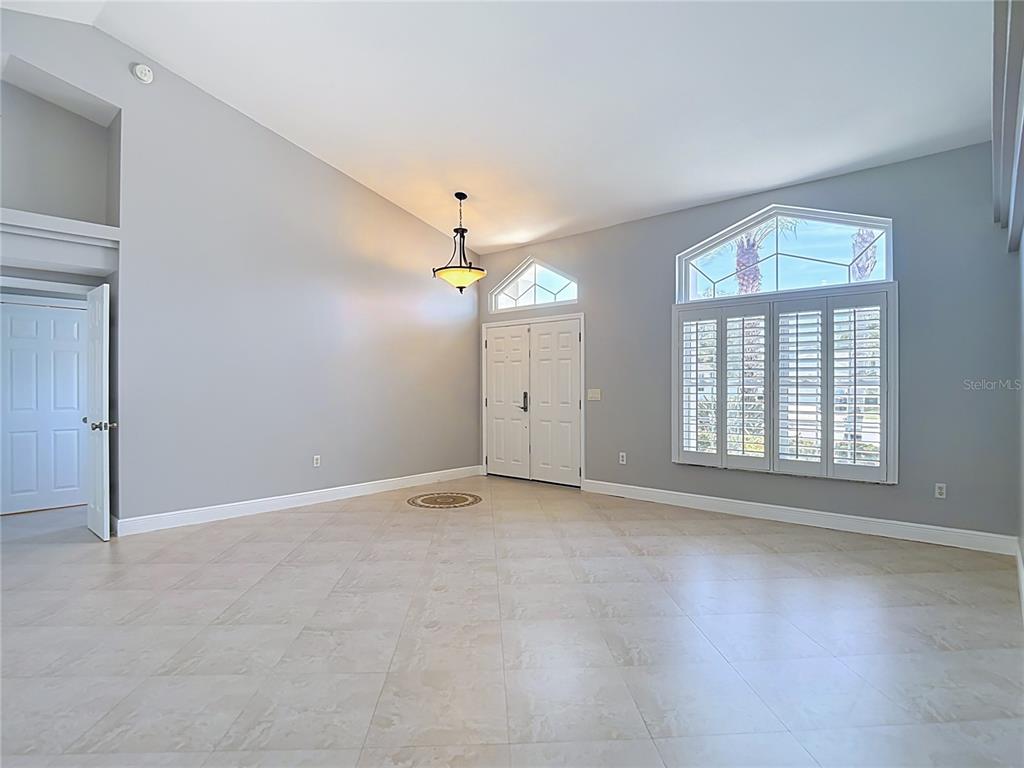 A spacious, light-filled entryway features vaulted ceilings, tile flooring, and a double front door — 4105 ANGEL WING COURT, LUTZ, FL