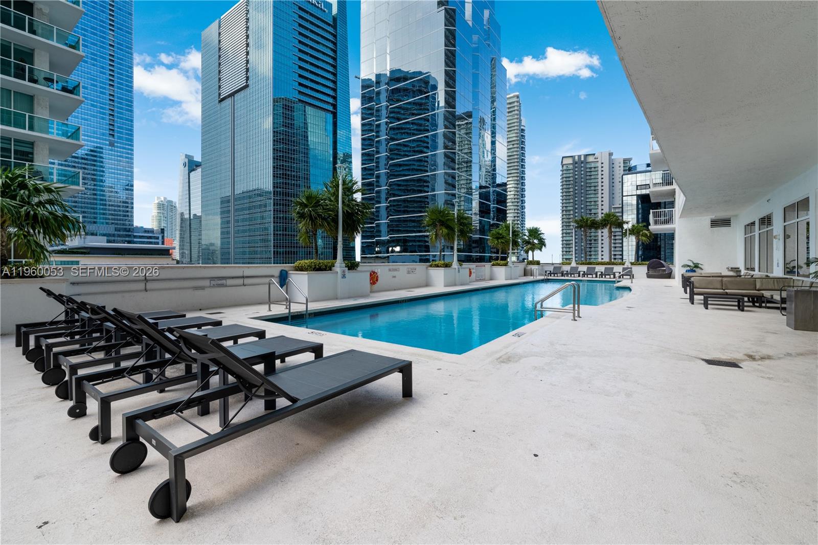 An outdoor swimming pool surrounded by lounge chairs on a high-rise building terrace — 1200 Brickell Bay Dr # 1705, Miami FL 33131, MIAMI, FL