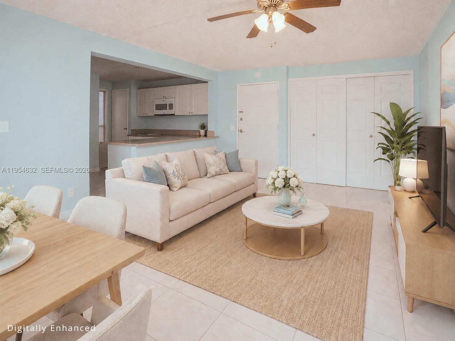 A living room with a beige sofa, round coffee table, and an adjacent kitchen area — 104 SW 9th St # 1101, Miami FL 33130, MIAMI, FL