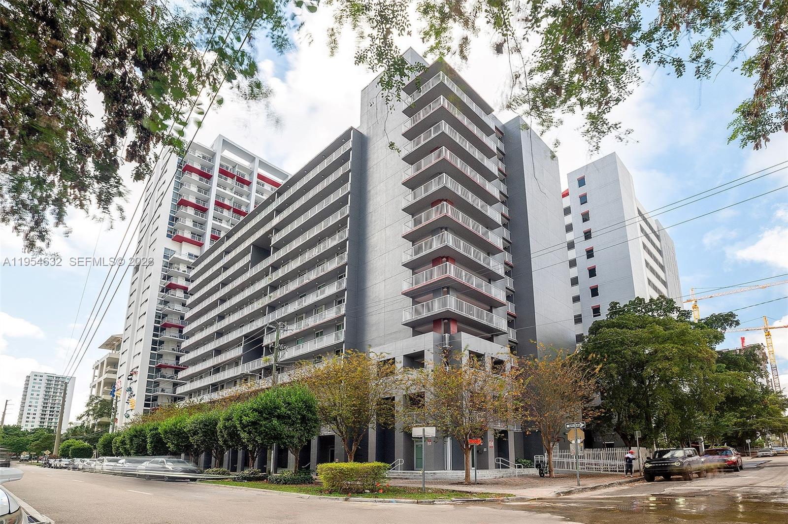 A multi-story gray apartment building features stacked balconies and a street-level entrance — 104 SW 9th St # 1101, Miami FL 33130, MIAMI, FL