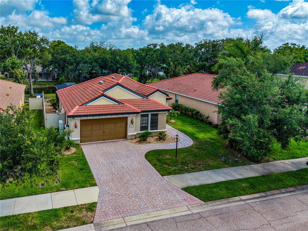 An aerial view of a single-story house with a red tile roof and paved driveway — 5624 AARON COURT, SARASOTA, FL