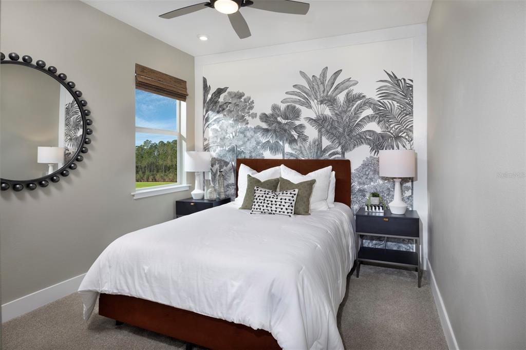 A bedroom features a brown upholstered bed, a palm-leaf mural, and a round wall mirror — 11383 BOUNDLESS TERRACE, VENICE, FL