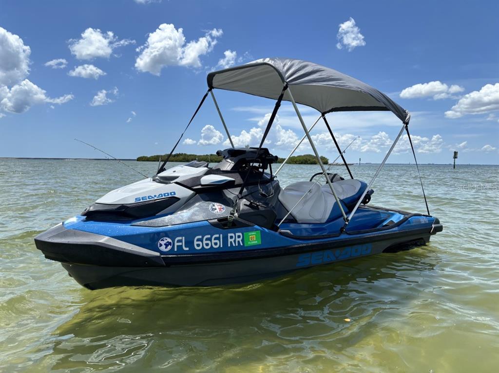 A blue Sea-Doo personal watercraft with a canopy is floating on calm water — 11521 SOUTHERN CREEK DRIVE, GIBSONTON, FL