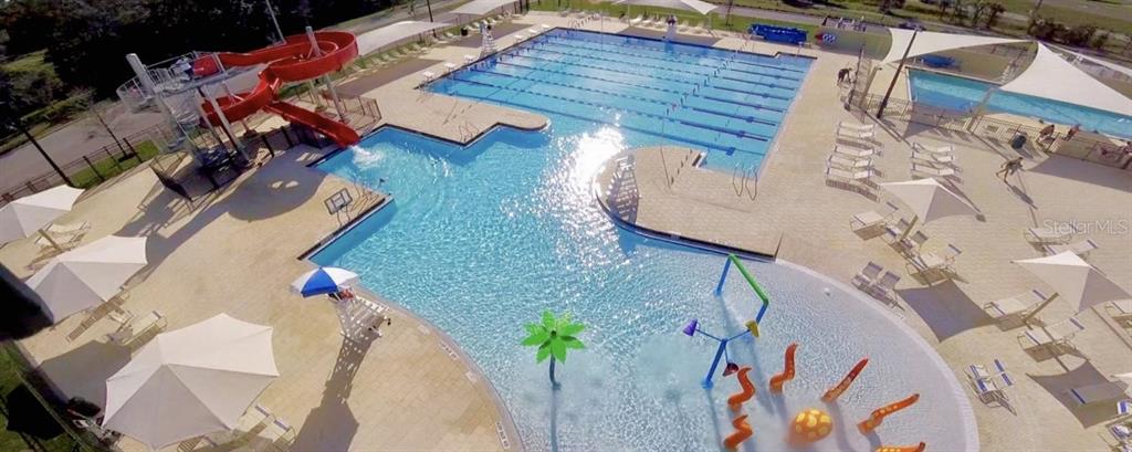 An aerial view of a community swimming pool complex featuring a waterslide and splash pad — 11521 SOUTHERN CREEK DRIVE, GIBSONTON, FL