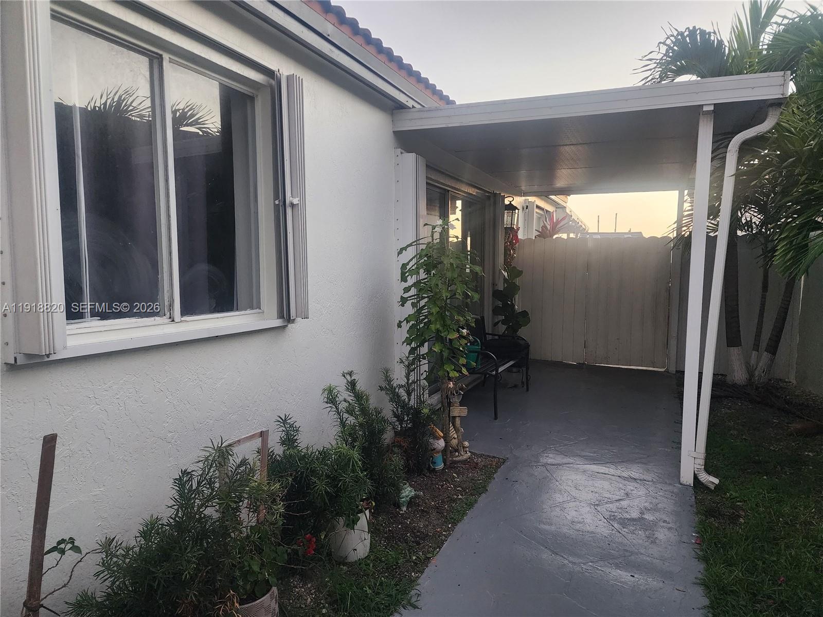 A white house exterior features a covered patio area with a gray concrete floor — 14291 SW 171st Ter, Miami FL 33177, MIAMI, FL