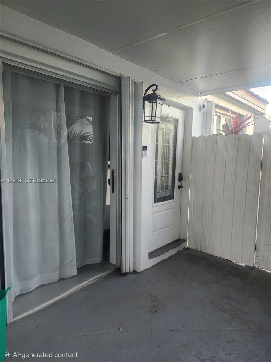 A covered patio features a sliding glass door, a white front door, and a privacy fence — 14291 SW 171st Ter, Miami FL 33177, MIAMI, FL