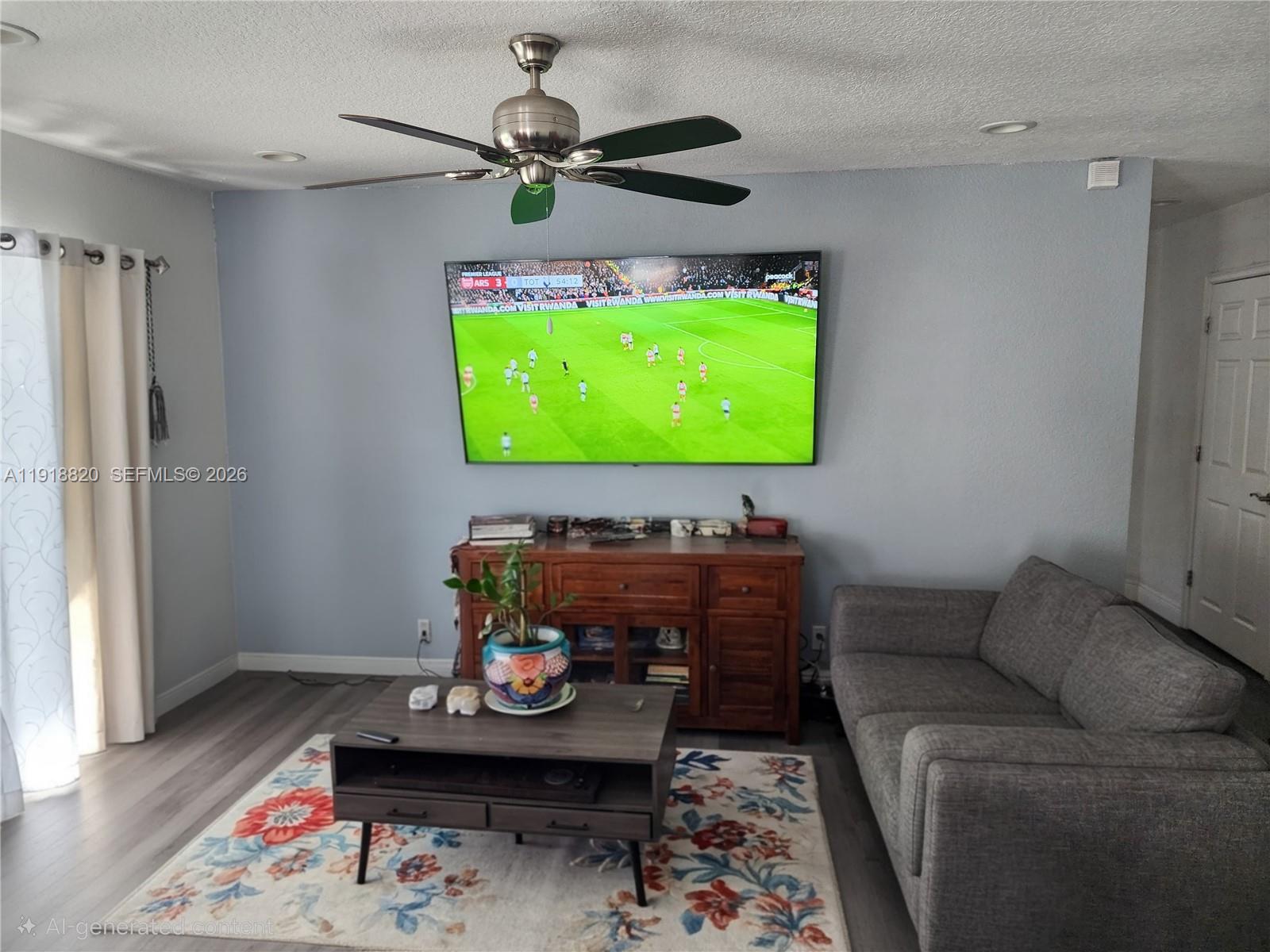 A living room features a wall-mounted television, a wooden media console, and a gray sofa — 14291 SW 171st Ter, Miami FL 33177, MIAMI, FL