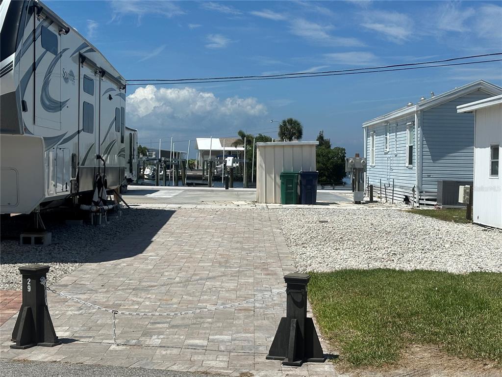 A paved and gravel lot sits between a parked RV and a mobile home — 29 MONTEGO DRIVE, PALMETTO, FL