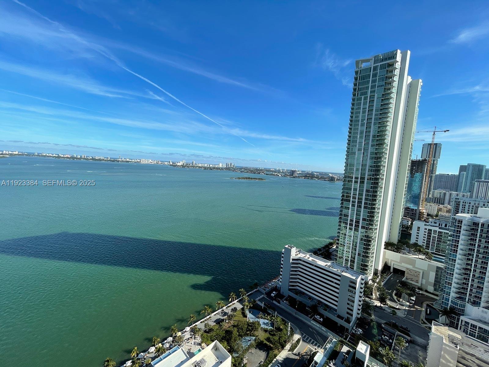 An elevated view of a coastal city skyline featuring a tall skyscraper and bay — 650 NE 32nd St # 3005, Miami FL 33137, MIAMI, FL