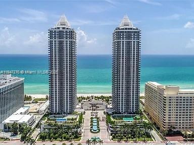 An aerial view shows two tall residential towers situated on a beach by the ocean — 4775 Collins Ave # 2105, Miami Beach FL 33140, MIAMI BEACH, FL