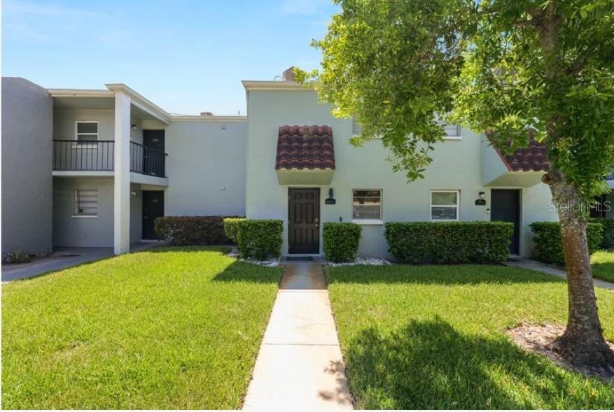 A two-story apartment building with light green stucco walls, a walkway, and manicured landscaping — 2862 SOMERSET PARK DRIVE UNIT 2862, TAMPA, FL