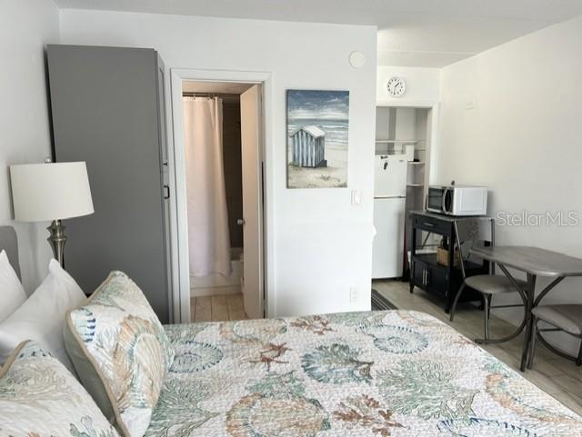 A bedroom features a bed with a seashell quilt, a small kitchenette, and a bathroom — 908 VILLAS DRIVE UNIT 68, VENICE, FL