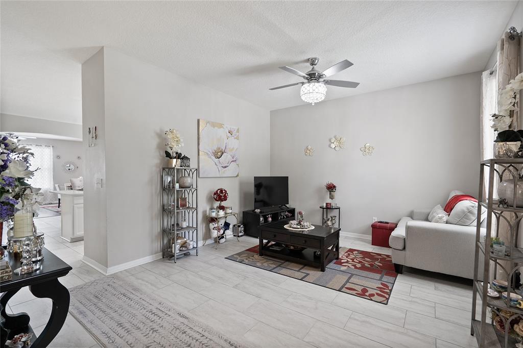 A living room features light tile flooring, a ceiling fan, and a neutral color palette — 12532 SAWGRASS OAK STREET, ORLANDO, FL